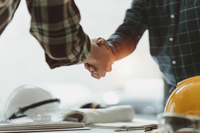 two people shaking hands in a professional setting representing partnership teamwork and success in the construction industry six collaboration relationships and projects