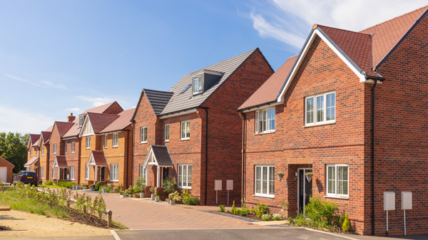 row of new brick houses in a residential area with clear blue sky and sunlight highlighting the architecture showing modern design features and landscaped gardens 1 home design 1 architecture 1 property development 1 neighborhood
