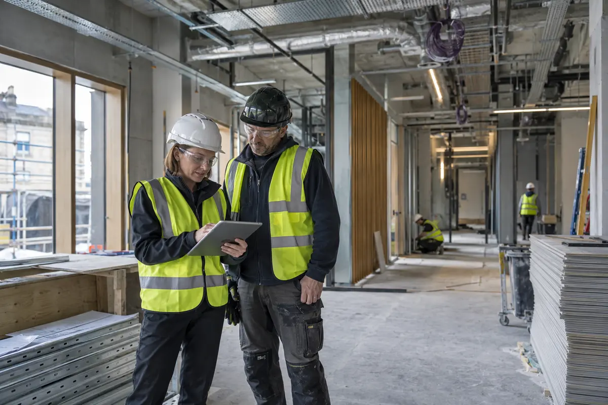 Quantity surveyor and site manager reviewing progress on a UK refurbishment project