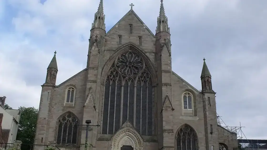 The stone west front and towers of Worcester Cathedral viewed beneath an overcast sky.