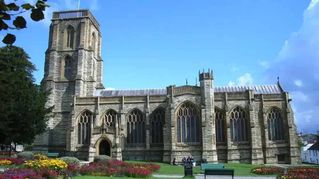 The historic stone Church of St John the Baptist in central Yeovil beneath a clear sky.