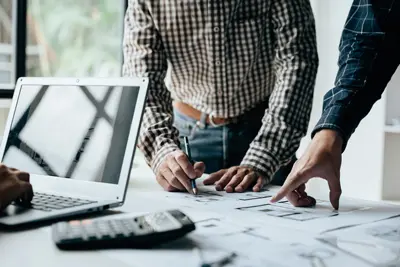 Quantity surveyors reviewing drawings, measurements and project costs